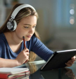 Mujer con auriculares estudiando online
